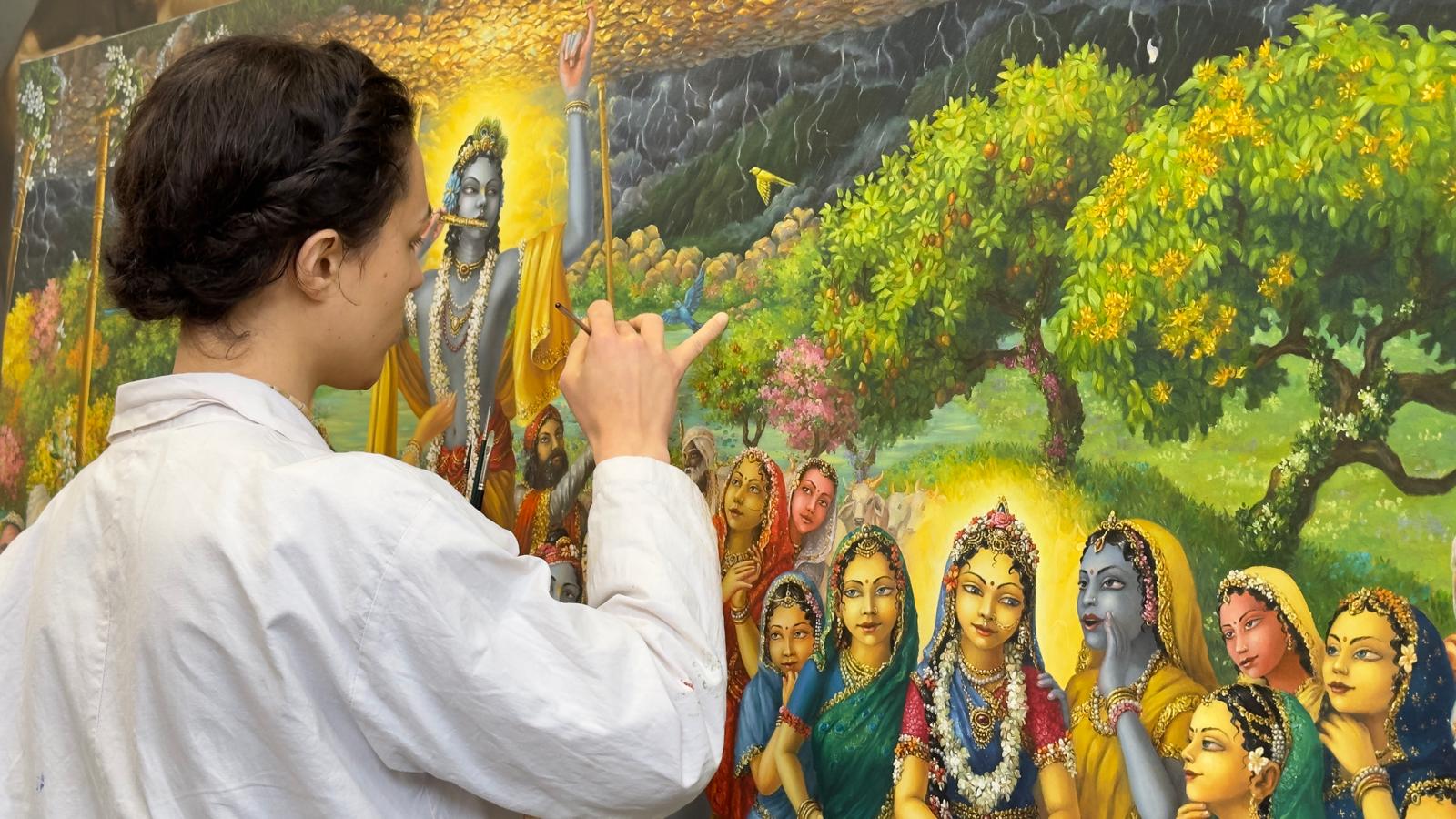 Artist at work painting devotional Krishna art
